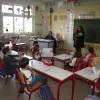 Αίθουσα σχολείου με μαθητές στα θρανία και δασκάλα