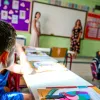 σχολείο, τάξη, δασκάλα κάνει μάθημε σε μαθητές που κάθονται στα θρανία