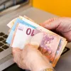 Γυναίκα συνταξιούχους μετράει ευρώ σε χαρτονομίσματα