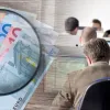 Χρήματα σε ευρώ, μεγεθυντικός φακός και υπάλληλοι σε υπολογιστές