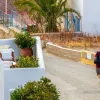 Άνδρας περπατάει με βαλίτσα στο χέρι σε νησί