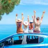 Χαρούμενοι τουρίστες σε αυτοκίνητο με θέα τη θάλασσα, επωφελούμενοι από τα νέα vouchers έως 300 ευρώ για διακοπές το 2026
