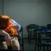 Κουρασμένη δασκάλα έχει ξαπλώσει πάνω σε θρανίο τάξης