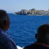 Δύο συνταξιούχοι κάθονται σε παγκάκι και κοιτάζουν τη θάλασσα το καλοκαίρι