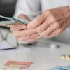 Γυναίκα συνταξιούχους μετράει χρήματα συνταξιοδότησης – αλλαγές στη φορολογία για πρόωρη σύνταξη και ΤΕΑ