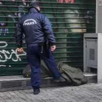 Άνδρας της ΕΛΑΣ σκουντάει άστεγο