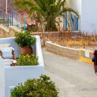 Άνδρας περπατάει με βαλίτσα στο χέρι σε νησί