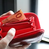 Άδειο πορτοφόλι με ένα χαρτονόμισμα 