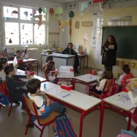 Αίθουσα σχολείου με μαθητές στα θρανία και δασκάλα