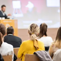 Φοιτητές σε Πανεπιστήμιο ακούνε καθηγητή να μιλάει με γυρισμένη πλάτη στην κάμερα