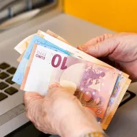 Γυναίκα συνταξιούχους μετράει ευρώ σε χαρτονομίσματα