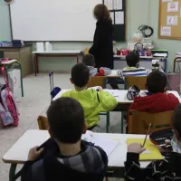 Αίθουσα σχολείου με μαθητές στα θρανία και δασκάλα