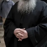 Ιερέας που δεν φαίνεται το πρόσωπό του και φοράει άμφια έχει τα χέρια του σταυρωμένα