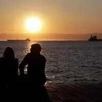 Ζευγάρι κοιτάει το ηλιοβασίλεμα στη θάλασσα