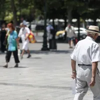 συνταξιούχος περπατάει στην πλατεία Συντάγματος