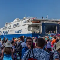 Άνθρωποι σε λιμάνι περιμένουν την επιβίβαση σε πλοίο για διακοπές