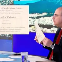 Ο Μακάριος Λαζαρίδης δείχνει το πτυχίο του σε εκπομπή