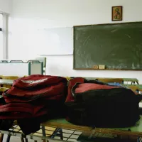 Άδεια σχολική τάξη με τσάντες πάνω σε θρανίο 