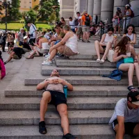 Καύσωνας στην Ευρώπη από τον θερμικό θόλο, άνθρωποι κάθονται και είναι ξαπλωμένοι λόγω ζέστης