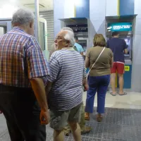 Συνταξιούχοι περιμένουν στην ουρά του ΑΤΜ για να πληρωθούν οι συντάξεις
