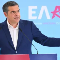 Ο Αλέξης Τσίπρας με φόντο λογότυπο της ΕΛΑΣ