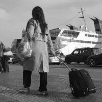 Γυναίκα εκπαιδευτικός αναπληρώτρια με βαλίτσα στο χέρι ετοιμάζει να μπει σε καράβι