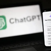 Υπολογιστής και κινητό που δείχνουν το λογότυπο του ChatGPT