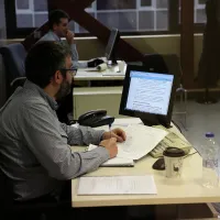 Προιστάμενος εργαζόμενοι δημόσιος υπάλληλος στο Δημόσιο κοιτάζει υπολογιστή