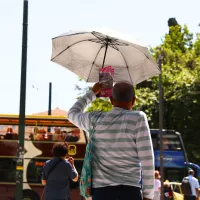 Άνδρας κρατάει ομπρέλα για τον ήλιο εν μέσω καύσωνα στην Αθήνα