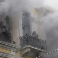 Γυναίκα στο μπαλκόνι της τράπεζας Marfin μέσα σε καπνούς από τον εμπρησμό το 2010