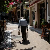 Συνταξιούχος περπατάει σε σοκάκι της Αθήνας