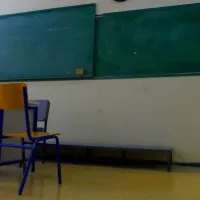 Άδεια αίθουσα τάξης μετά την απόλυση δασκάλας, φαίνεται καρέκλα, έδρα και πίνακας