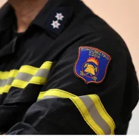 Πυροσβέστης όπου στο μανίκι του έχει λογότυπο της Πυροσβεστικής