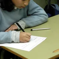 Μαθήτρια σε σχολείο γράφει με χαρτί