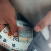 Άνδρας μετράει χρήματα μέσα από πορτοφόλι