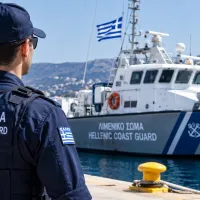 Στέλεχος του Λιμενικού κοιτάζει βάρκα του ΛΣ-ΕΛΑΚΤ