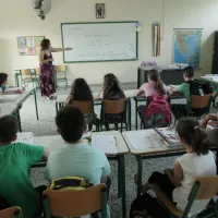 Γυναίκα εκπαιδευτικός παραθέτει μάθημα σε σχολική τάξη