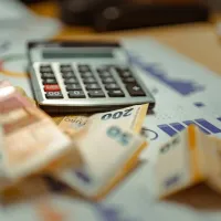 Χρήματα σε χαρτονομίσματα ευρώ δίπλα από κομπιουτεράκι