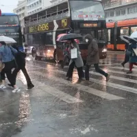 Άνθρωποι με ομπρέλες στον δρόμο τρέχουν από βροχή και κακοκαιρία