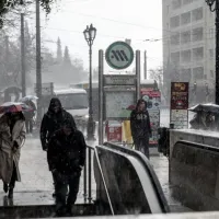 Κόσμος περπατάει μέσα στην κακοκαιρία σε σταθμό του Μετρό στην Αθήνα