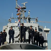 Άνδες και γυναίκες του Λιμενικού Σώματος ποζάρουν επάνω σε σκάφος του Λιμενικού