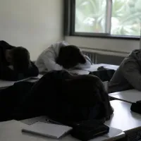 Μαθητές με σκυμμένα κεφάλια πάνω σε θρανία στις Πανελλαδικές εξετάσεις
