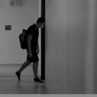 Μαθητής περπατάει μέσα σε σχολείο σε ασπρόμαυρη φωτογραφία