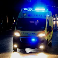 Ασθενοφόρο του ΕΚΑΒ με σειρήνες το βράδυ σε δρόμο