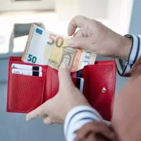 Γυναίκα μετράει χρήματα στο πορτοφόλι της