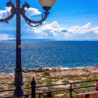 Γυναίκες κάθονται σε παγκάκι σε παραλία με καλό καιρό τον χειμώνα
