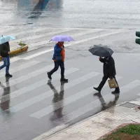 Βροχές και καταιγίδες στην Αθήνα με κόσμο να περνάει τον δρόμο με ομπρέλες