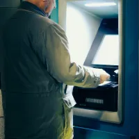Άνδρας σηκώνει τη σύνταξή του με χρήματα από ATM τράπεζας