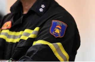 Πυροσβέστης όπου στο μανίκι του έχει λογότυπο της Πυροσβεστικής