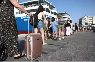 Γυναίκα με τη βαλίτσα στο χέρι ετοιμάζεται να μπει σε πλοίο